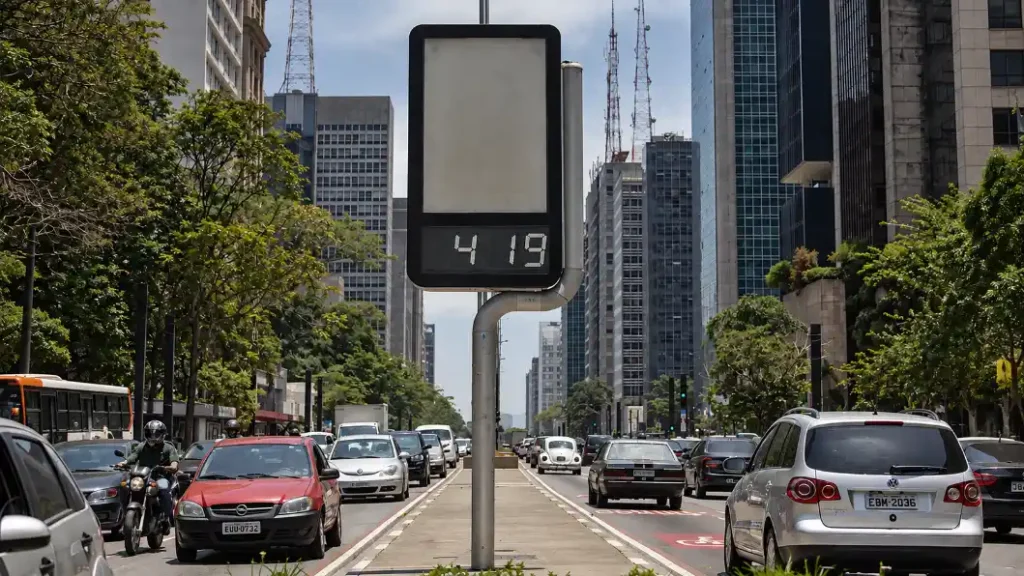 El Niño e saúde: Termômetro digital mostra alta temperatura em uma avenida movimentada com carros e prédios altos ao fundo