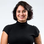 Lais Furtado em retrato sorridente, usando blusa de gola alta preta, em fundo claro. Expressão confiante e profissional, ideal para temas de liderança.