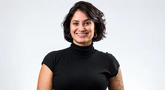 Lais Furtado em retrato sorridente, usando blusa de gola alta preta, em fundo claro. Expressão confiante e profissional, ideal para temas de liderança.